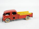 a red toy truck with a yellow top on a white surface
