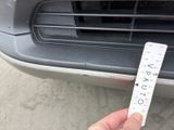 a person holding a ruler in front of a car