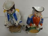 two figurines of a man and a woman sitting on top of each other
