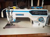 a white and blue sewing machine sitting on a table