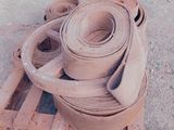 Plusieurs rouleaux d'argile sont posés sur une palette dans un parking