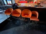four orange chairs sitting in front of a bar
