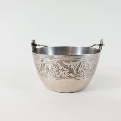 an antique silver plated bowl with a handle on a white background
