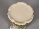 a white vase with a green and yellow design on it