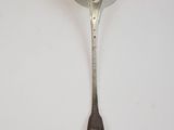 silver spoon with a diamond on it sitting on a white surface