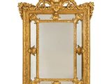 un miroir à cadre doré orné d'un motif décoratif