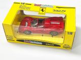 une petite voiture rouge dans une boîte jaune posée sur une surface blanche
