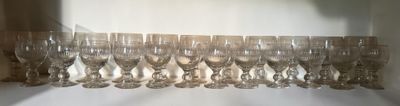 many wine glasses lined up on a shelf next to a window