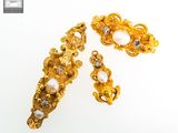 a close up of a pair of gold and pearl jewelry