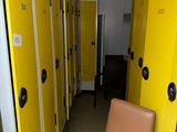 yellow lockers line a hallway with a chair in the middle of it