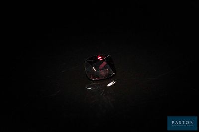 gros plan d'un diamant rouge sur une surface noire