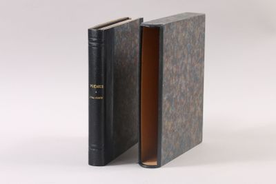 an open book with a black cover sitting on top of a white surface
