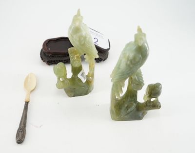 deux figurines vertes posées à côté d'une cuillère et d'un repose-cuillère