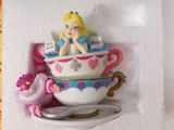 a small figurine of a girl in a teacup with a spoon