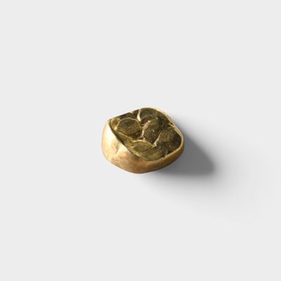 a close up of a gold ring on a white surface