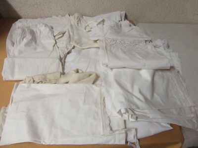 a lot of white cloths on a table next to each other