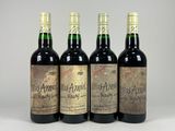 four bottles of wine sitting on top of a white surface
