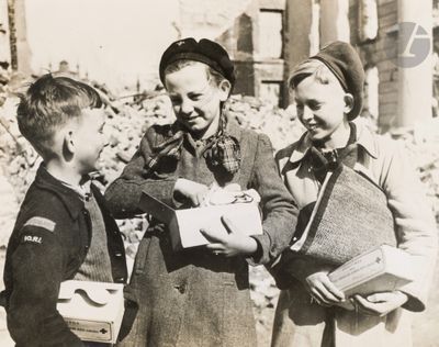 three children standing next to each other and one is holding a piece of paper