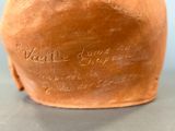 a brown vase with writing on it sitting on a table