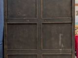 a tall wooden cabinet with four doors in the middle of a room