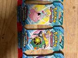 four packs of pokemon trading cards on a wooden table