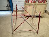 a red and silver metal frame in the middle of a room