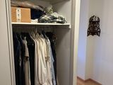 a closet with a lot of clothes hanging on the shelves
