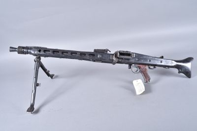 an old machine gun on a tripod stand on a white surface