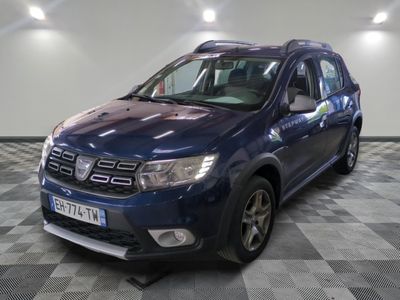 La Dacia bleue est garée dans le garage, sur un sol à damier.