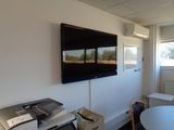 a flat screen tv mounted on the wall in a small room