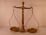 une balance en or sur laquelle se trouve une paire de flèches