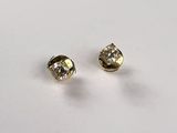 a pair of diamond stud earrings on a white surface