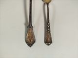 two spoons and a fork on a white surface
