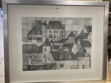 drawing of a village in a frame on a shelf in a room