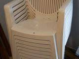 une chaise en plastique blanche posée sur un sol carrelé