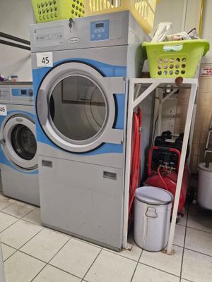 une rangée de lave-linge et de sèche-linge dans une buanderie