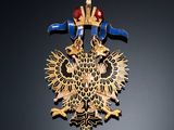 an image of a gold and blue broochle with a bird on it
