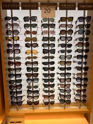 many different shades of sunglasses on display in a display case