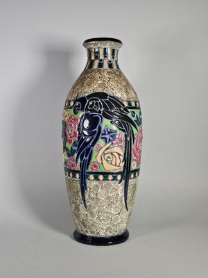 un vase sur lequel est peint un oiseau, posé sur une table