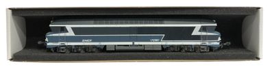 un petit train posé dans une boîte sur une surface blanche