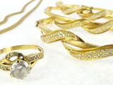 a lot of gold jewelry on a white surface