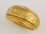 an image of a gold ring on a white surface