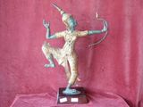 statue en bronze représentant un homme tenant un arc et une flèche, posée sur un tissu rouge