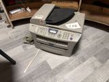 a printer that is sitting on the floor next to a chair