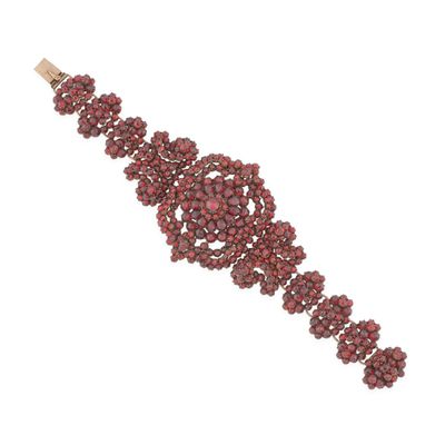 un gros plan d'un bracelet avec des perles rouges sur fond blanc