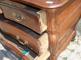 une table en bois avec trois tiroirs et un oiseau posé dessus