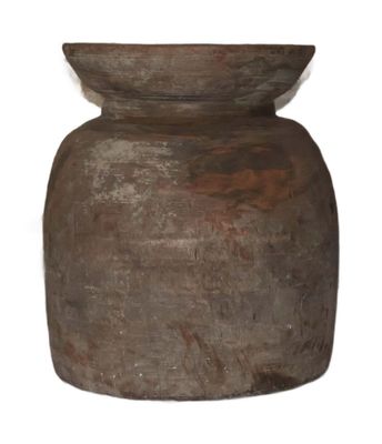 a brown vase that is sitting on a white surface