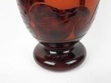 a glass vase with a red design on it