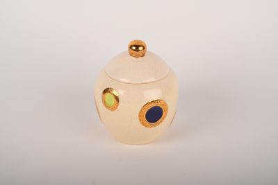 pot en céramique de couleur crème avec des pois bleus et verts sur le couvercle