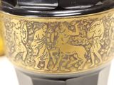 a black and gold coffee cup sitting on a table